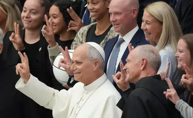 From left, Villanova's guards Elijah Crawford, and Brady Muller present Pope Leo XIV with a personalized Villanova's jersey as they meet in the Paul VI Hall at the Vatican, Saturday, Oct. 31, 2026, during an audience with some 7,000 university representatives and supporters from Villanova University and the University of Notre Dame, including members of their men's and women's basketball teams, ahead of the Eternal City Tip-Off, a men's and women's college basketball doubleheader in Rome on Nov. 1. (AP Photo/Gregorio Borgia)
