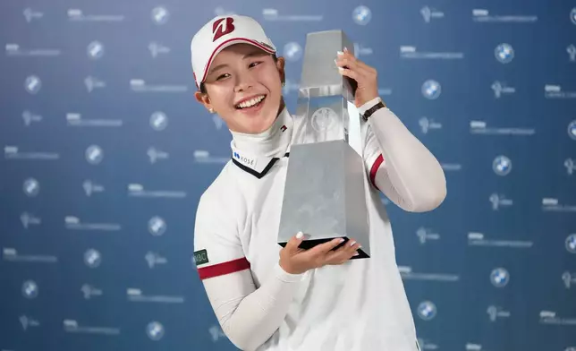 Yuri Yoshida of Japan celebrates with the winner's trophy following the final round of the LPGA BMW Ladies Championship at the Pine Beach Golf Links, in Haenam, South Korea, Sunday, Oct. 25, 2026. (AP Photo/Lee Jin-man)