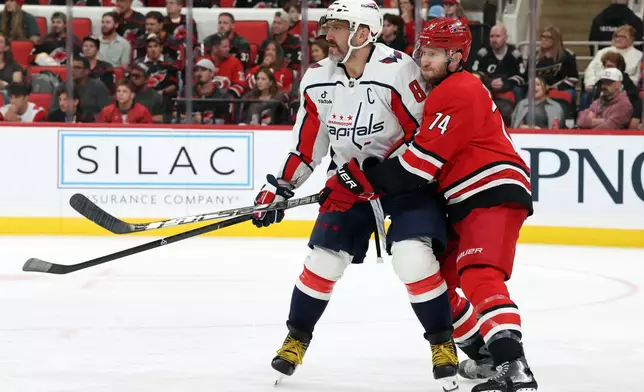 Carolina Hurricanes' Jaccob Slavin (74) defends against Washington Capitals' Alex Ovechkin (8) during the third period of an NHL hockey game in Raleigh, N.C., Friday, Oct. 2, 2026. (AP Photo/Karl DeBlaker)