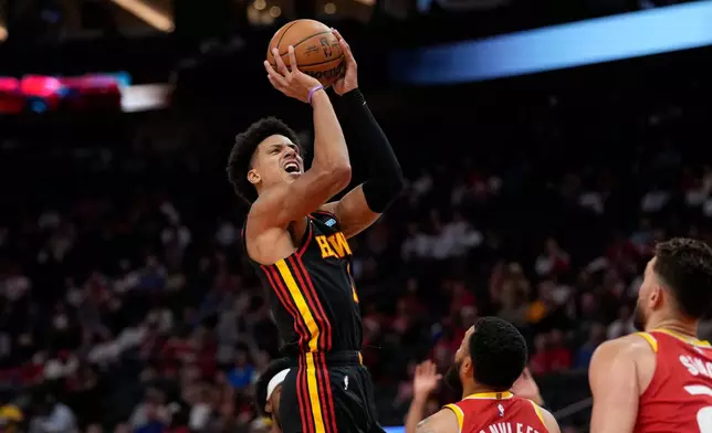 Atlanta Hawks forward Jalen Johnson, top, goes up to shoot during the first quarter of an NBA basketball game against the Houston Rockets, Monday, Oct. 26, 2026, in Houston. (AP Photo/Kevin M. Cox)