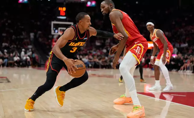 Atlanta Hawks guard CJ McCollum (3) is defended by Houston Rockets forward Kevin Durant, front right, during the first quarter of an NBA basketball game Monday, Oct. 26, 2026, in Houston. (AP Photo/Kevin M. Cox)