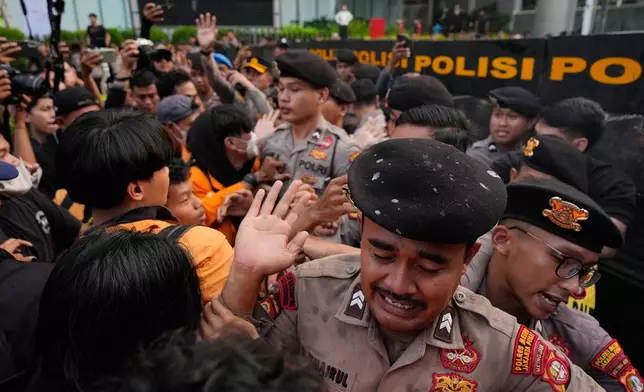 Police officers react as they scuffle with student protesters during a rally marking the second year since Indonesian President Prabowo Subianto took office in Jakarta, Indonesia, Tuesday, Oct. 20, 2026. (AP Photo/Dita Alangkara)