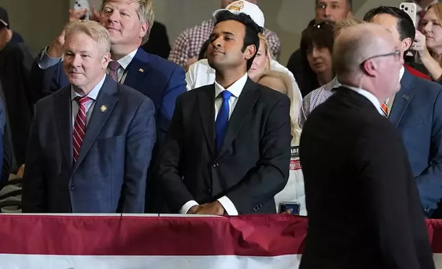 Ohio gubernatorial candidate Vivek Ramaswamy, center, listens to Vice President JD Vance speak during a campaign rally at the Sharonville Convention Center, Wednesday, Oct. 21, 2026, in Sharonville, Ohio. (AP Photo/Jacquelyn Martin, Pool)