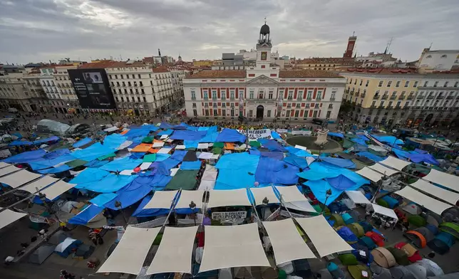 Activists camp during a protest following the eviction last Wednesday of 87-year-old Maricarmen to demand stronger laws to protect renters at Sol square in Madrid, Spain, Wednesday, Sept. 30, 2026. (AP Photo/Manu Fernandez)