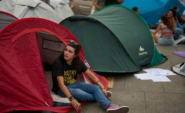 A woman camps during a protest following the eviction last Wednesday of 87-year-old Maricarmen to demand stronger laws to protect renters at Sol square in Madrid, Spain, Sunday, Sept. 27, 2026. (AP Photo/Manu Fernandez)