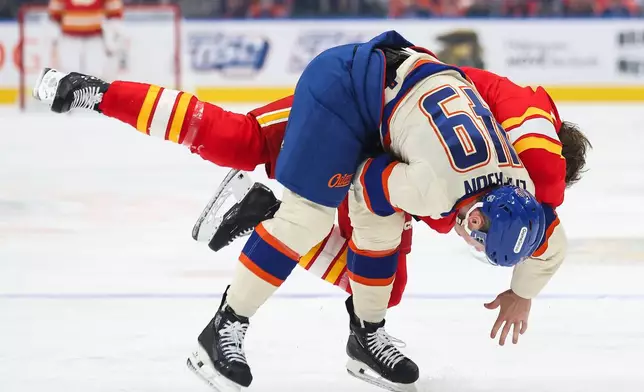 Edmonton Oilers' Ty Emberson (49) fights Calgary Flames' Brennan Othmann during the first period of an NHL hockey game in Edmonton, Alberta, Wednesday, Oct. 28, 2026. (Codie McLachlan/The Canadian Press via AP)