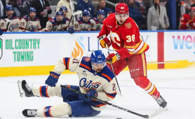 Edmonton Oilers' Mathieu Joseph (21) battles against Calgary Flames' Jonathan Castagna (38) during the first period of an NHL hockey game in Edmonton, Wednesday, Oct. 28, 2026. (Codie McLachlan/The Canadian Press via AP)