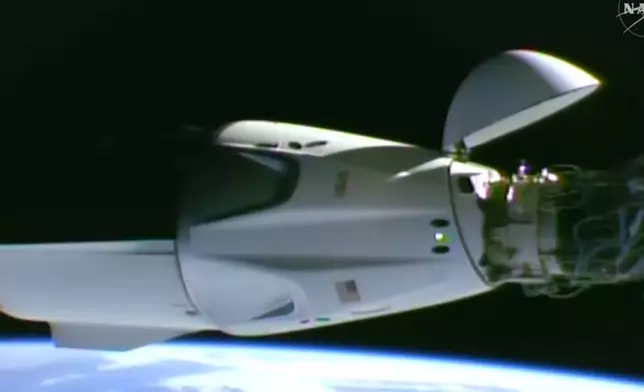 This image taken from video by NASA shows a SpaceX capsule carrying four astronauts docking at the International Space Station, Thursday, Oct. 1, 2026. (NASA via AP)