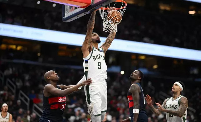 Milwaukee Bucks center Kel'el Ware (9) dunks against Washington Wizards forward Khris Middleton, left, during the first half of an NBA basketball game, Wednesday, Oct. 21, 2026, in Washington. (AP Photo/Nick Wass)