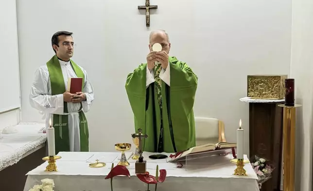 This picture, released by Vatican Media on Friday, Oct. 16, 2026, shows Pope Leo XIV, flanked by his personal secretary, Monsignor Edgard Iván Rimaycuna Inga, left, celebrating Mass at the Agostino Gemelli Polyclinic in Rome, where he is recovering after having cancer removed from his right lung. (Vatican Media via AP)