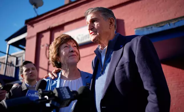 Sen. Susan Collins listens as former West Virginia Sen. Joe Manchin speaks to reporters following a campaign stop Wednesday, Oct. 21, 2026, in Lewiston, Maine. (AP Photo/Robert F. Bukaty)