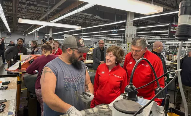 In this photo taken with a smartphone, Sen. Susan Collins, R-Maine, and former Sen. Joe Manchin, D-W.Va., tour a New Balance shoe factory in Norway, Maine, on Wednesday, Oct. 21, 2026. (AP Photo/Patrick Whittle)