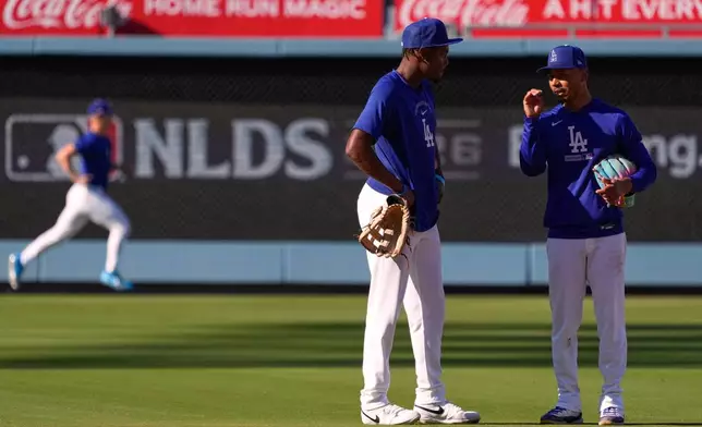 Los Angeles Dodgers' Mookie Betts, right, and Josue de Paula chat during practice ahead of a baseball NL Division Series Thursday, Oct. 1, 2026, in Los Angeles. (AP Photo/Mark J. Terrill)