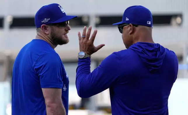 Los Angeles Dodgers third baseman Max Muncy, left, talks with manager Dave Roberts during practice ahead of a baseball NL Division Series Thursday, Oct. 1, 2026, in Los Angeles. (AP Photo/Mark J. Terrill)