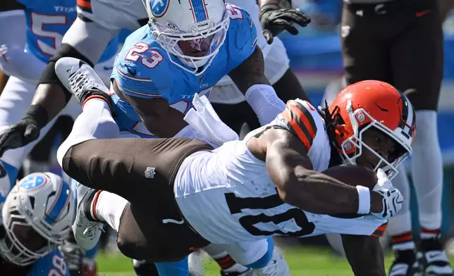 Cleveland Browns running back Quinshon Judkins (10) dives past Tennessee Titans safety Kevin Winston Jr. (23) and defensive tackle Jeffery Simmons (98) to score a touchdown during the first half of an NFL football game in Nashville, Tenn., Sunday, Oct. 25, 2026. (AP Photo/John Amis)