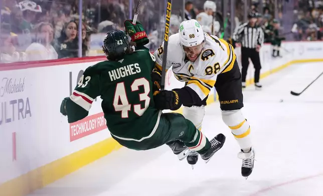 Boston Bruins right wing David Pastrnak (88) checks Minnesota Wild defenseman Quinn Hughes (43) during the second period of an NHL hockey game Saturday, Oct. 3, 2026, in St. Paul, Minn. (AP Photo/Bailey Hillesheim)