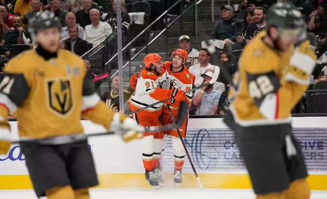 Anaheim Ducks center Leo Carlsson (91) and right wing Beckett Sennecke (45) celebrate after Sennecke scored against the Vegas Golden Knights during the first period of an NHL hockey game Friday, Oct. 2, 2026, in Las Vegas. (AP Photo/John Locher)