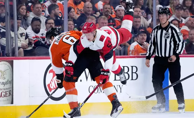 Carolina Hurricanes' Jackson Blake, center, collides with Philadelphia Flyers' Travis Sanheim, left, during the first period of an NHL hockey game Saturday, Oct. 3, 2026, in Philadelphia. (AP Photo/Matt Slocum)