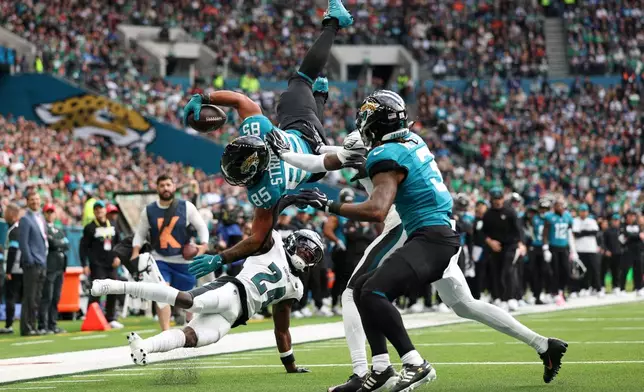 Jacksonville Jaguars tight end Brenton Strange (85) is flipped through the air as he is held just short of the end zone during an NFL football game against Philadelphia Eagles in London, Sunday, Oct. 11, 2026. (AP Photo/Ian Walton)