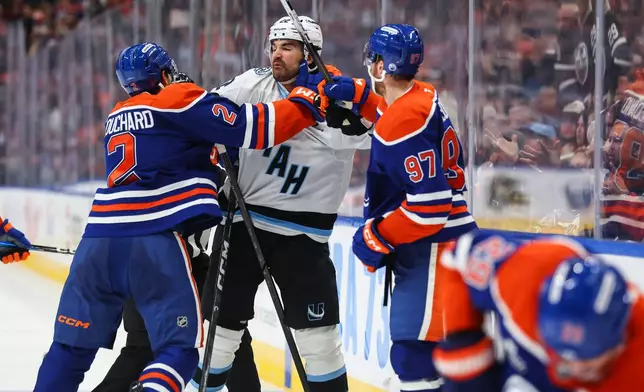 Edmonton Oilers' Evan Bouchard (2) and Connor McDavid (97) shove Utah Mammoth's Jack McBain, center, after a hit on Oilers' Leon Draisaitl (29) during the second period of an NHL hockey game in Edmonton, Alberta, Thursday, Oct. 15, 2026. (Codie McLachlan/The Canadian Press via AP)