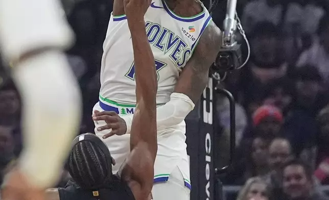 Minnesota Timberwolves guard Ayo Dosunmu, top, blocks a shot by Cleveland Cavaliers guard Peyton Watson (8) in the first half of an NBA basketball game, Monday, Oct. 26, 2026, in Cleveland. (AP Photo/Sue Ogrocki)