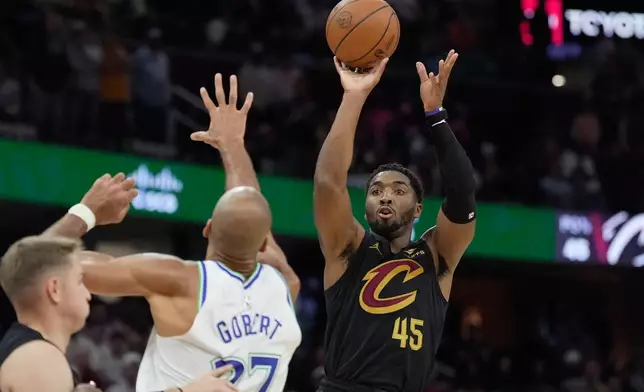 Cleveland Cavaliers guard Donovan Mitchell (45) shoots over Minnesota Timberwolves center Rudy Gobert (27) in the second half of an NBA basketball game, Monday, Oct. 26, 2026, in Cleveland. (AP Photo/Sue Ogrocki.
