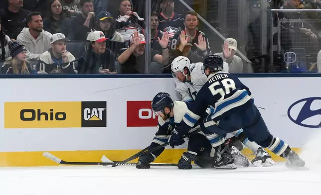Columbus Blue Jackets' left wing Danton Heinen (58) and right wing Mathieu Olivier (24) defend against Utah Mammoth defenseman Andrew Peeke (20) during the second period of an NHL hockey game, Saturday, Oct. 3, 2026, in Columbus, Ohio. (AP Photo/Tanner Pearson)