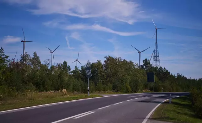 A newly constructed wind turbine, right, whose rotor tips reach a maximum height of 365 meters (1,198 feet), stands in Schipkau, Germany, Thursday, Oct. 1, 2026. (AP Photo/Markus Schreiber)