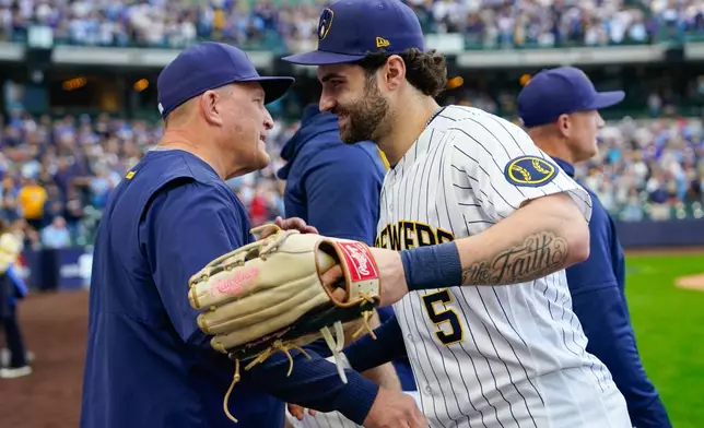 Milwaukee Brewers center fielder Garrett Mitchell (5) shakes hands with manager Pat Murphy, left, after a baseball game against the St. Louis Cardinals, Sunday, Sept. 27, 2026, in Milwaukee. (AP Photo/Kayla Wolf)