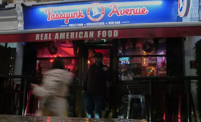 Pedestrians walk past the entrance of the Passyunk Avenue bar, a sports bar in London, Wednesday, Oct. 7, 2026. (AP Photo/Alastair Grant)