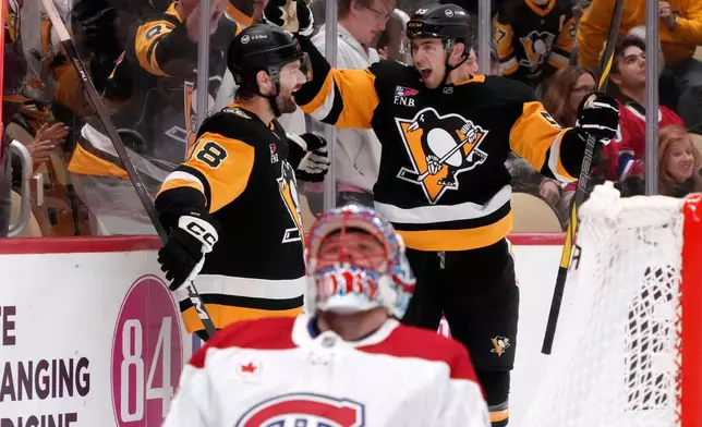 Pittsburgh Penguins' Tommy Novak (18) celebrates his goal with Egor Chinakhov, right rear, as Montréal Canadiens goaltender Jakub Dobes, foreground, collects himself during the second period of an NHL hockey game in Pittsburgh, Saturday, Oct. 3, 2026. (AP Photo/Gene J. Puskar)