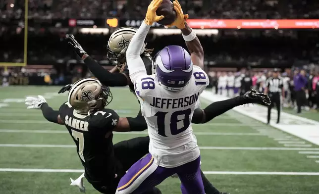 Minnesota Vikings wide receiver Justin Jefferson (18) catches a touchdown pass against New Orleans Saints safety Jonas Sanker (7) and cornerback Quincy Riley during the second half of an NFL football game in New Orleans, Sunday, Oct. 11, 2026. (AP Photo/Matthew Hinton)