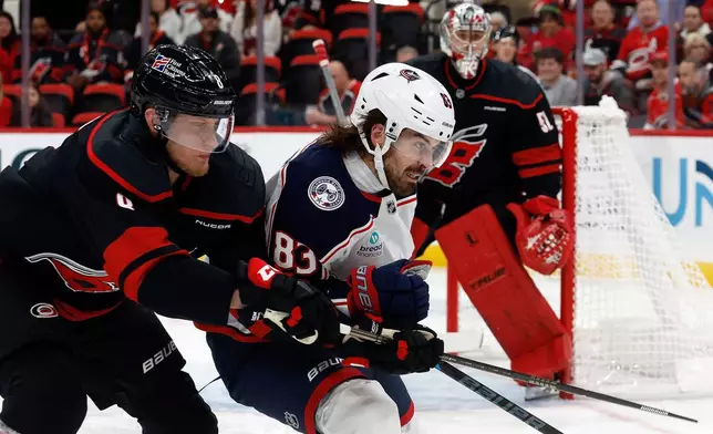 Carolina Hurricanes' Juuso Välimäki (8) collides with Columbus Blue Jackets' Conor Garland (83) during the first period of an NHL hockey game in Raleigh, N.C., Thursday, Oct. 29, 2026. (AP Photo/Karl DeBlaker)
