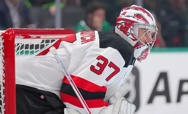 New Jersey Devils goaltender Connor Hellebuyck defends his net during the first period of an NHL hockey game against the Dallas Stars, Tuesday, Oct. 27, 2026, in Dallas. (AP Photo/Julio Cortez)