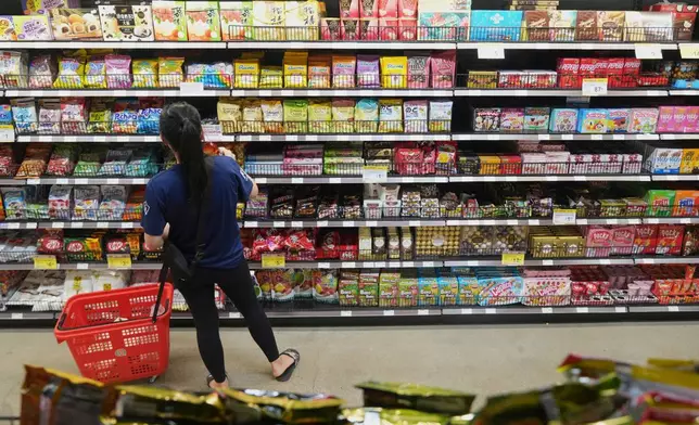FILE - A customer buys Chinese made ginger candy at 99 Ranch Market, an Asian grocery store in Los Angeles, April 7, 2025. (AP Photo/Damian Dovarganes, File)