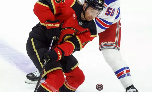 Ottawa Senators' Jake Sanderson (85) and New York Rangers' Will Cuylle (50) try to control the puck during second period NHL hockey action in Ottawa on Saturday, Oct. 24, 2026. (Patrick Doyle/The Canadian Press via AP)