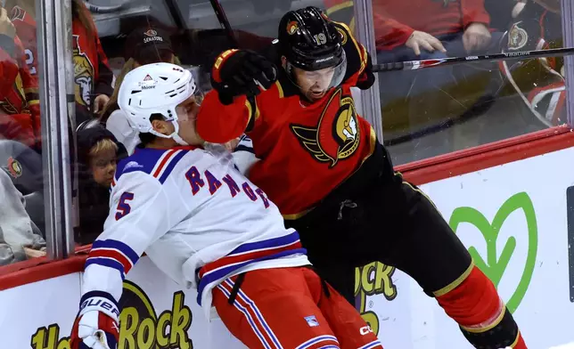 Ottawa Senators' Drake Batherson (19) collides with New York Rangers' Sean Durzi (5) during the first period of an NHL hockey game in Ottawa, Ontario, Saturday, Oct. 24, 2026. (Patrick Doyle/The Canadian Press via AP)