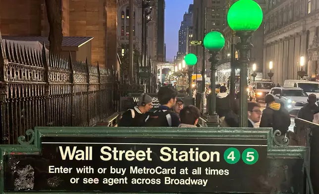 FILE - Commuters emerge from a Wall Street subway station in New York's Financial District on Wednesday, Oct. 30, 2024. (AP Photo/Peter Morgan, File)
