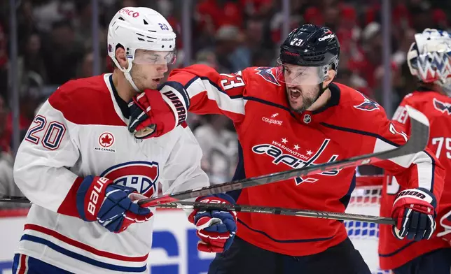 Washington Capitals defenseman Vincent Desharnais, right, and Montreal Canadiens left wing Juraj Slafkovsky (20) battle during the second period of an NHL hockey game, Wednesday, Oct. 14, 2026, in Washington. (AP Photo/Nick Wass)