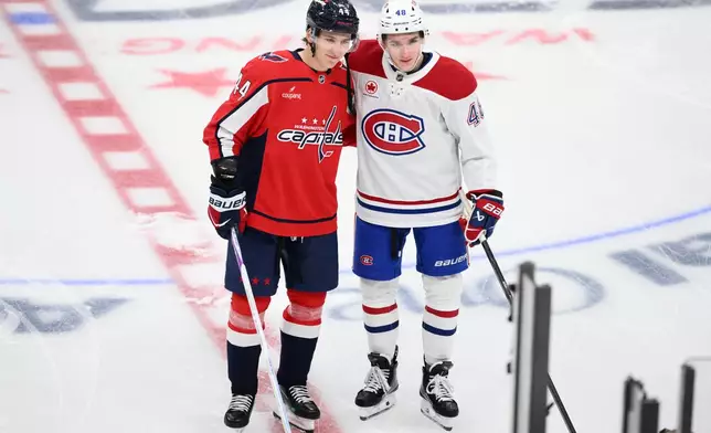 Washington Capitals defenseman Cole Hutson (44), left, and his brother Montreal Canadiens defenseman Lane Hutson (48), right, pose before an NHL hockey game, Wednesday, Oct. 14, 2026, in Washington. (AP Photo/Nick Wass)