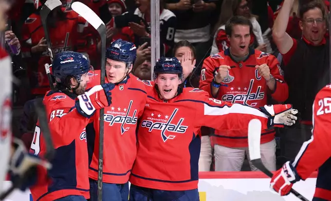 Washington Capitals left wing Ivan Miroshnichenko, right, celebrates his goal with left wing Ilya Protas (62) and right wing Alex Tuch, left, during the first period of an NHL hockey game against the Montreal Canadiens, Wednesday, Oct. 14, 2026, in Washington. (AP Photo/Nick Wass)