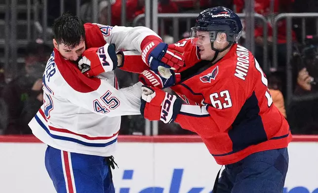 Washington Capitals left wing Ivan Miroshnichenko (63) scuffles with Montreal Canadiens defenseman Alexandre Carrier (45) during the second period of an NHL hockey game, Wednesday, Oct. 14, 2026, in Washington. (AP Photo/Nick Wass)