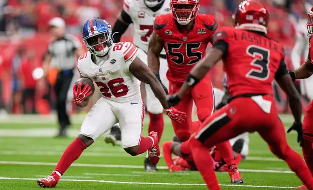 New York Giants running back Devin Singletary (26) breaks away from Houston Texans defenders to score the winning touchdown in overtime of an NFL football game in Houston, Sunday, Oct. 25, 2026. (AP Photo/Gerald Herbert)