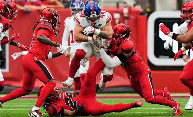 New York Giants running back Cam Skattebo (44) leaps over Houston Texans safety M.J. Stewart (29) and is tackled by linebacker Henry To'oto'o, right, during the first half of an NFL football game in Houston, Sunday, Oct. 25, 2026. (AP Photo/Gerald Herbert)
