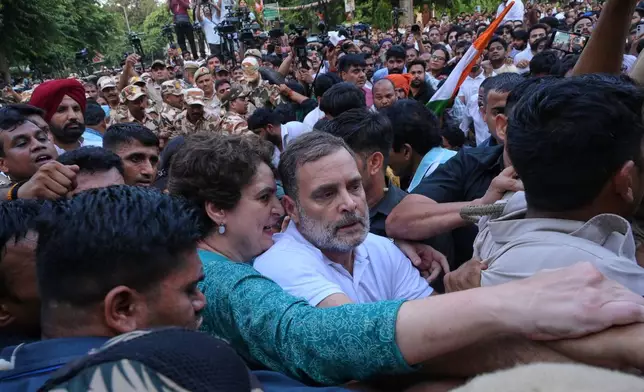 India's opposition Congress party leader Rahul Gandhi, center, and his sister, fellow lawmaker Priyanka Gandhi Vadra, jostle with police during a protest demanding the resignation of Chief Election Commissioner Gyanesh Kumar in New Delhi, India, Wednesday, Oct. 7, 2026. (AP Photo/Vipin)