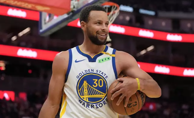 Golden State Warriors guard Stephen Curry (30) smiles during the second half of a preseason NBA basketball game against the Portland Trail Blazers, Friday, Oct. 16, 2026, in San Francisco. (AP Photo/Jeff Chiu)