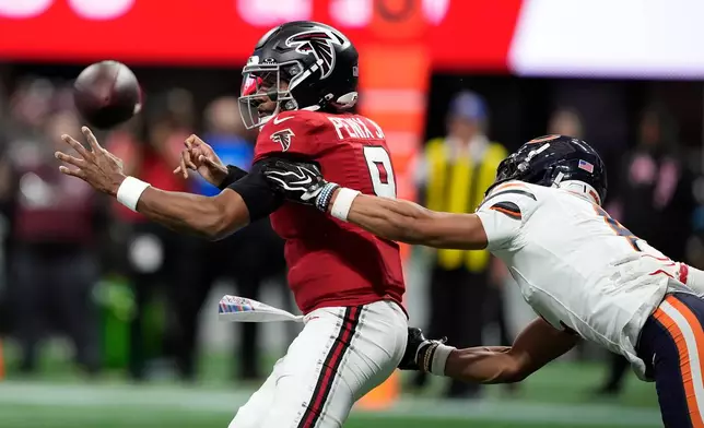Atlanta Falcons quarterback Michael Penix Jr. (9) loses control of the ball as he is hit by Chicago Bears cornerback Kyler Gordon during the second half of an NFL football game in Atlanta, Sunday, Oct. 18, 2026. (AP Photo/Brynn Anderson)