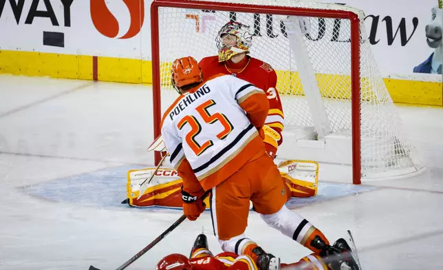 Anaheim Ducks' Ryan Poehling scores on Calgary Flames goalie Dustin Wolf during the third period of an NHL hockey game in Calgary, Alberta, Alberta, Saturday, Oct. 10, 2026. (Jeff McIntosh/The Canadian Press via AP)