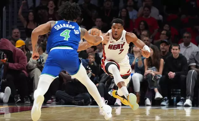 Miami Heat forward Giannis Antetokounmpo (7) vies with Minnesota Timberwolves guard Terrence Shannon Jr. (4) for the ball during the first half of an NBA basketball game, Wednesday, Oct. 21, 2026, in Miami. (AP Photo/Rebecca Blackwell)
