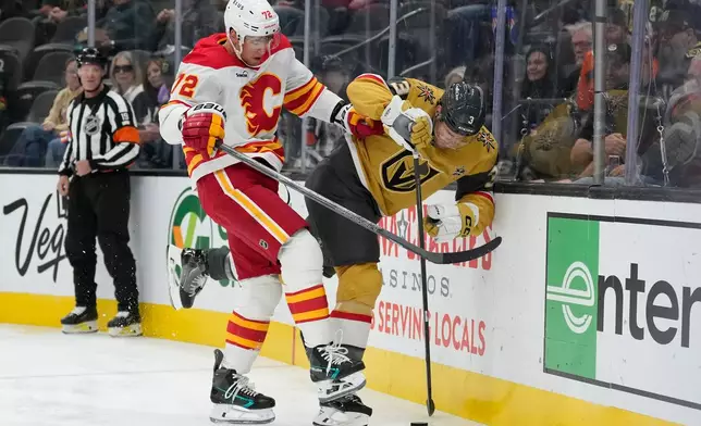 Calgary Flames right wing Maxim Tsyplakov (72) checks Vegas Golden Knights defenseman Brayden McNabb (3) during the first period of an NHL hockey game Thursday, Oct. 15, 2026, in Las Vegas. (AP Photo/John Locher)